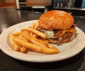 Cheeseburger with bacon and side of french fries. 