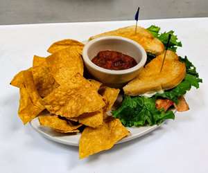 BLT sandwich with a side of chips and salsa. 