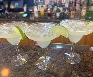 Three tasty margaritas with lime garnish. 
